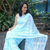 a woman wearing a light blue coloured chikankari saree